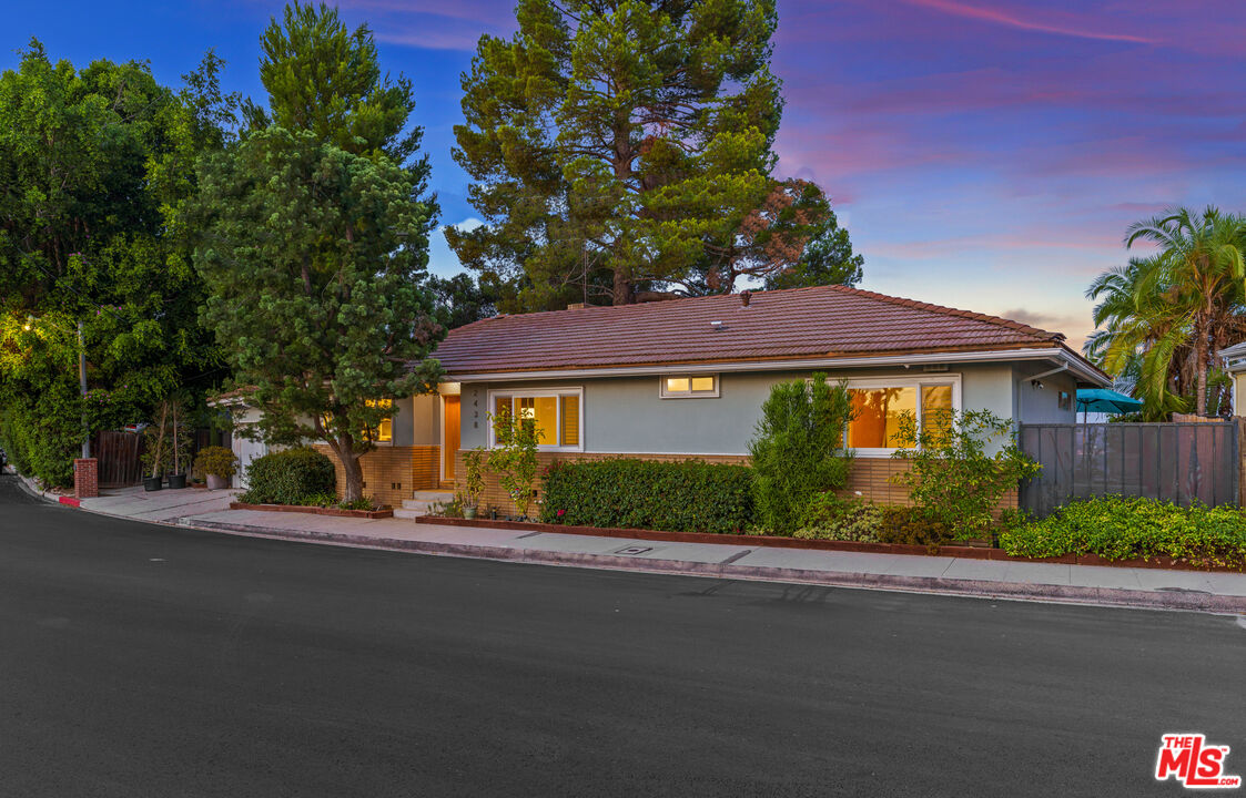 2438 Roscomare Road Los Angeles, CA 90077 - Photo 6 of 17 a front view of a house with a yard and garage