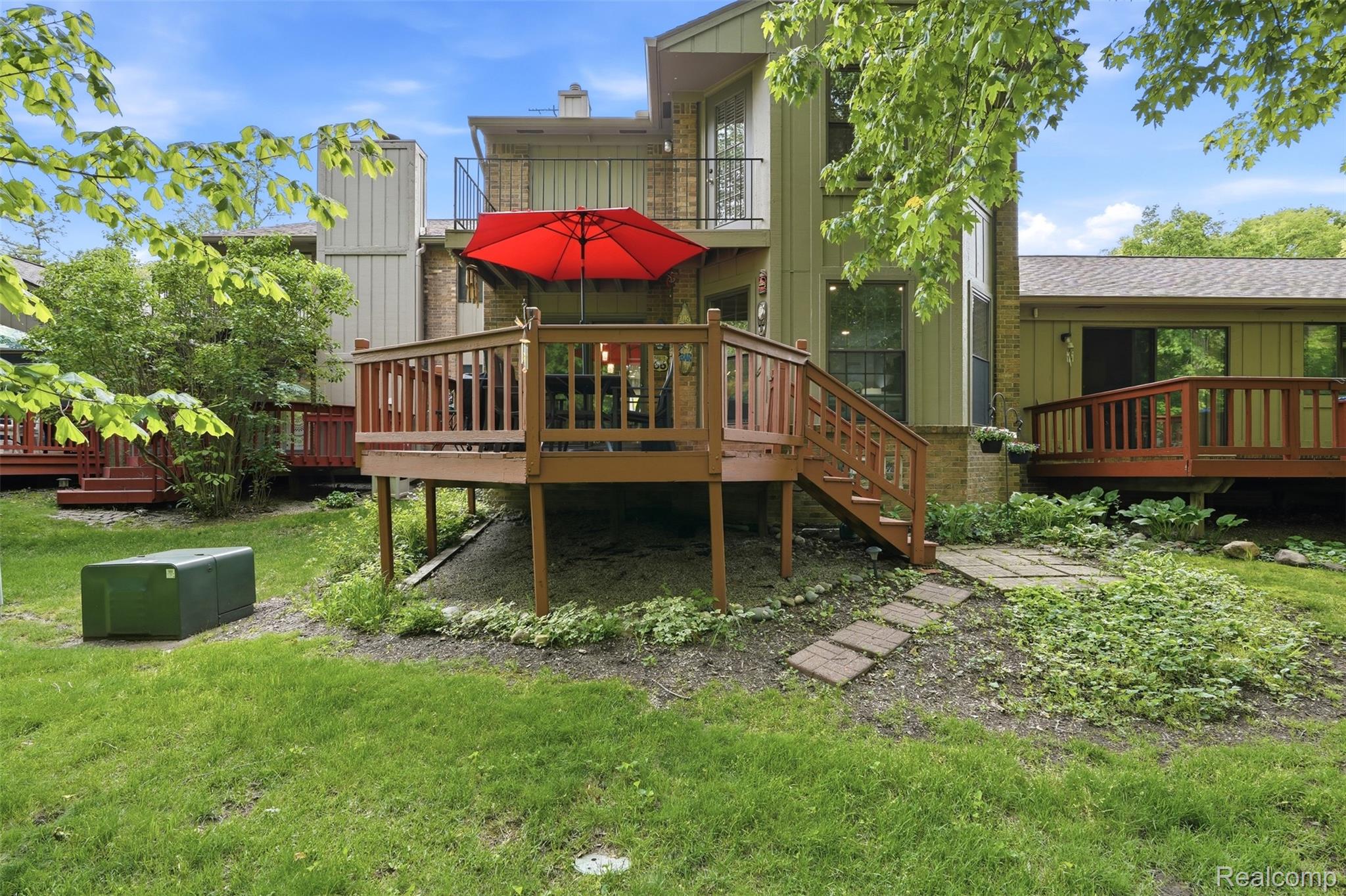 1687 Lodge Pole Lane Rochester, MI 48309 - Photo 31 of 53 Spacious wood deck with baluster railing, offering direct access to the lower lawn via a staircase