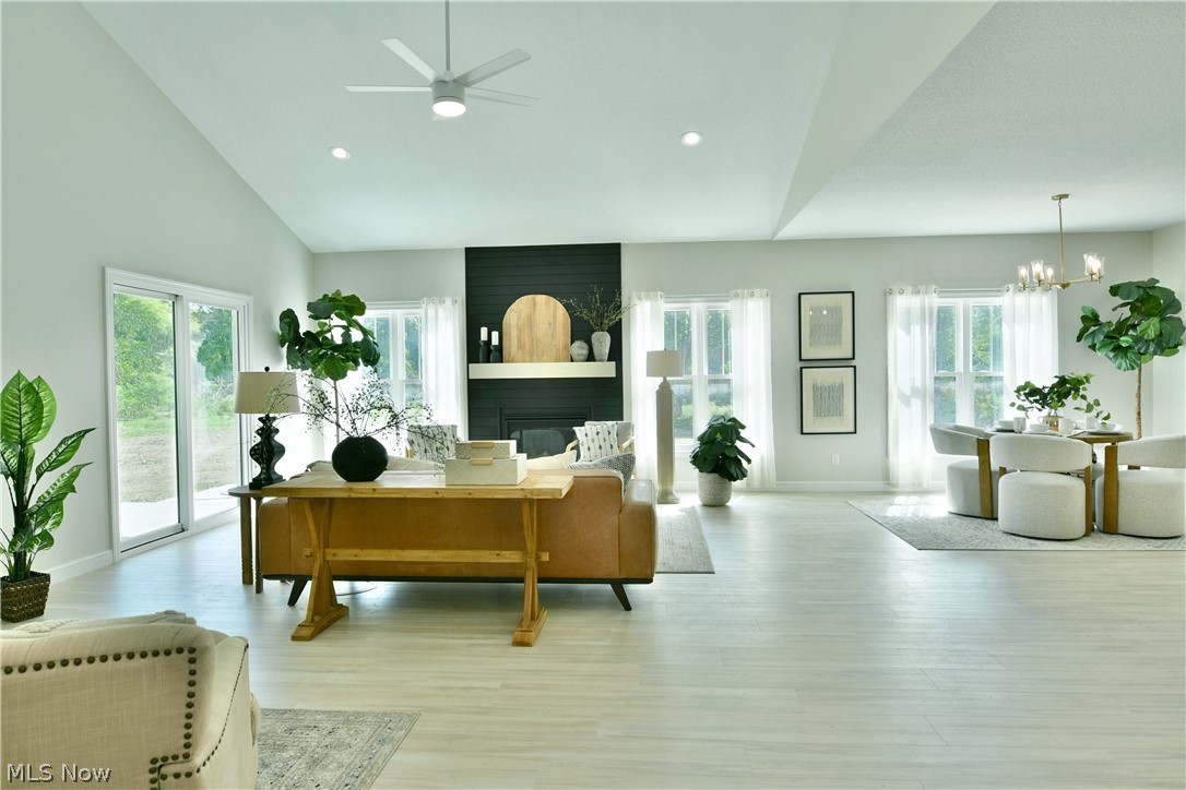 Vaulted ceilings, light wood-finish flooring, recessed lighting, and a modern ceiling fan