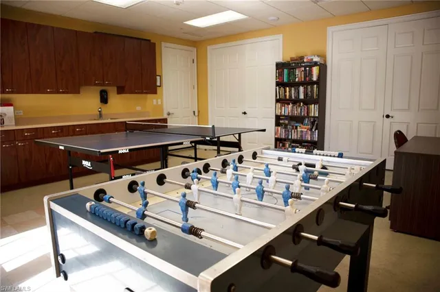 a living room with furniture pool table and chairs