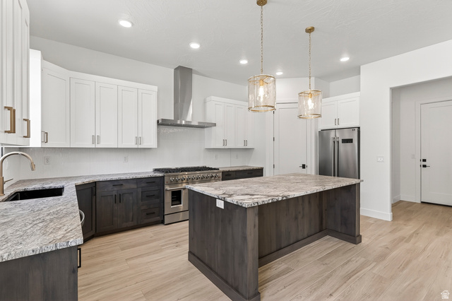 2862 South Mountain Rnch Road Cedar City, UT 84720 - Photo 11 of 64 Modern kitchen featuring light wood-finish flooring, a central island with a stone countertop, and two-tone cabinetry