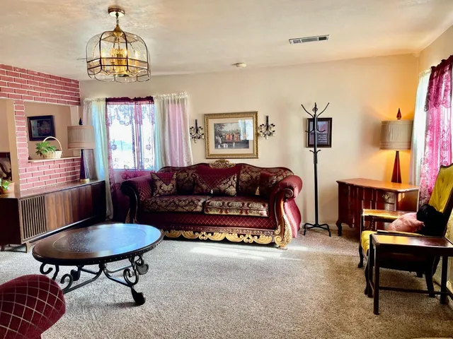 a living room with furniture and a chandelier