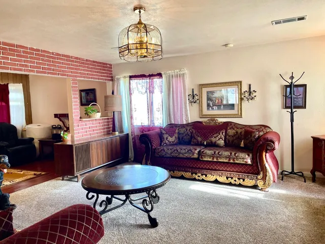 a living room with furniture a chandelier and a dining table