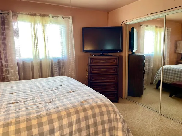 a bedroom with a bed and a flat screen tv