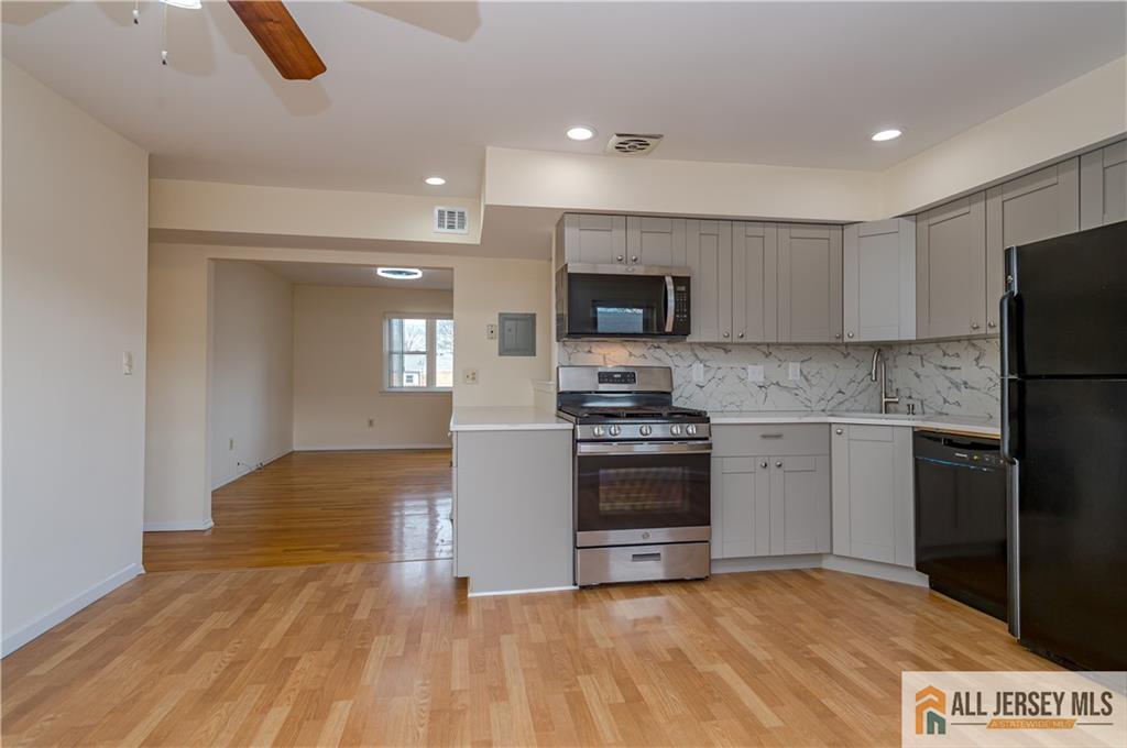 161 Evergreen Road, Unit 12B Edison, NJ 08837 - Photo 6 of 19 a kitchen with granite countertop a refrigerator and a stove top oven