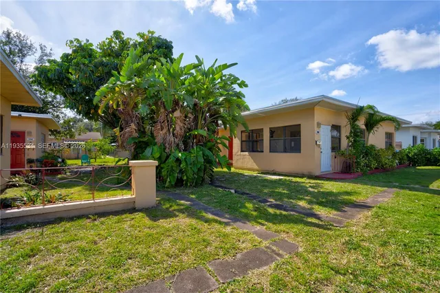 a view of a house with backyard and sitting area