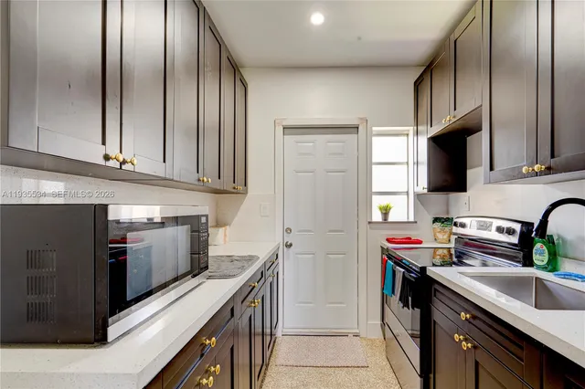 a kitchen with stainless steel appliances granite countertop a refrigerator sink and stove