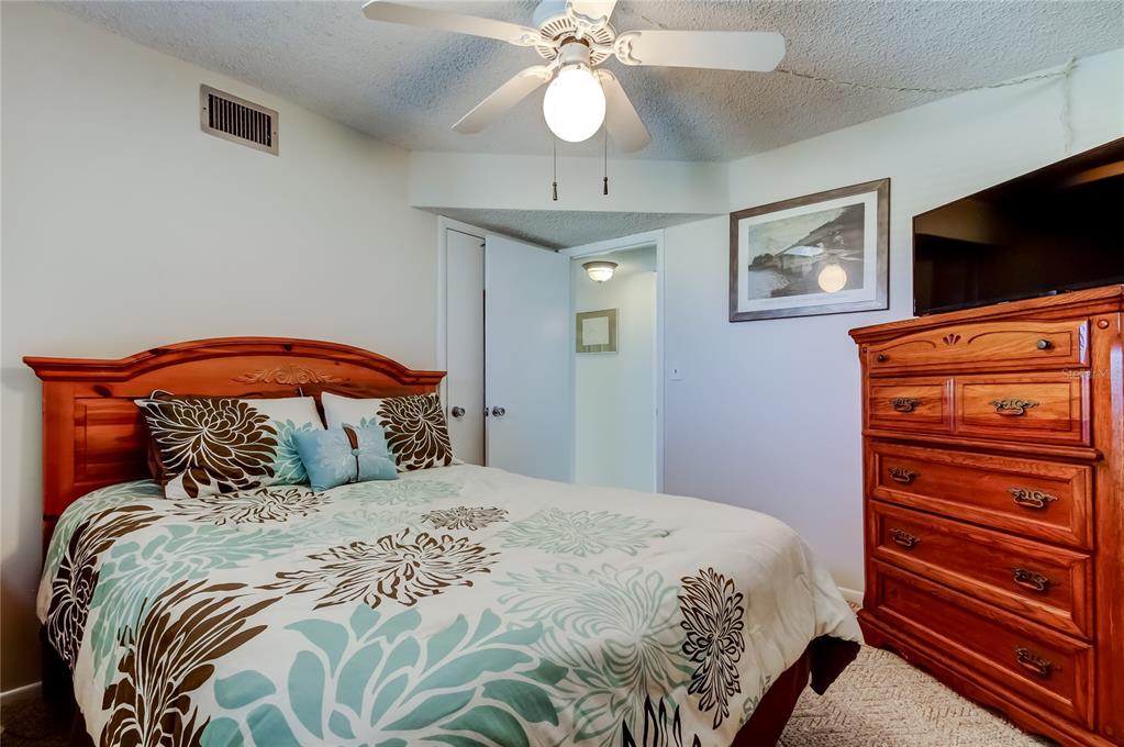 4775 Cove Circle, Unit 1008 St. Petersburg, FL 33708 - Photo 19 of 45 a bedroom with a bed and a flat screen tv