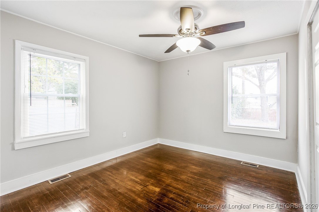 414 Mc Pherson Road Fayetteville, NC 28303 - Photo 11 of 16 an empty room with wooden floor ceiling fan and windows