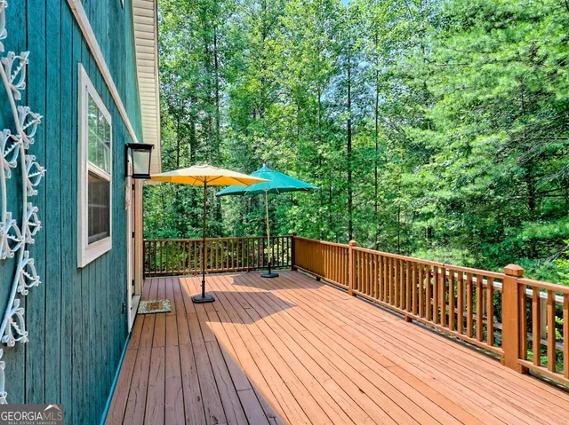 a balcony with wooden floor and outdoor seating