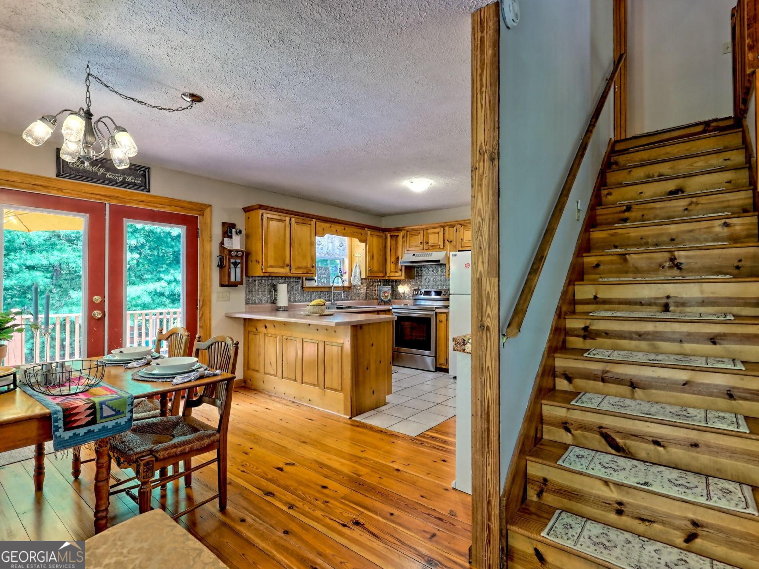 249 Spruce Creek Road Lakemont, GA 30552 - Photo 16 of 55 a dining room with furniture a chandelier and wooden floor