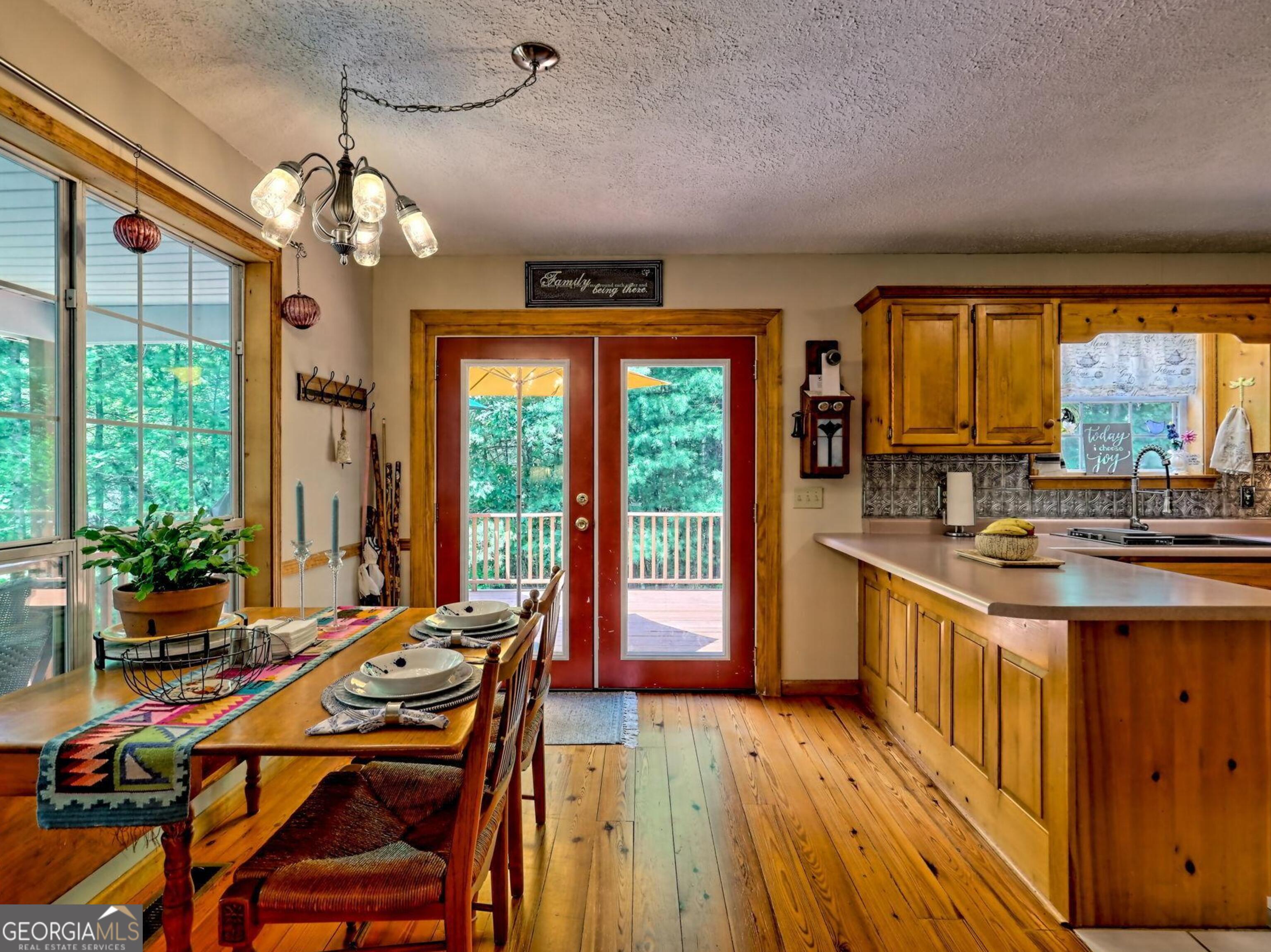 249 Spruce Creek Road Lakemont, GA 30552 - Photo 17 of 55 a kitchen with a table chairs stove and large window