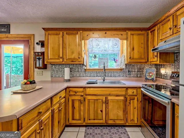 a kitchen with sink refrigerator dining table and chairs