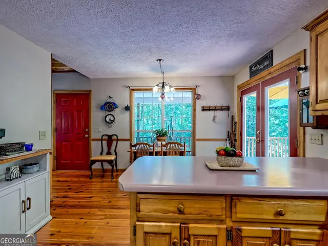 a large kitchen with stainless steel appliances a stove a sink dishwasher and white cabinets with wooden floor