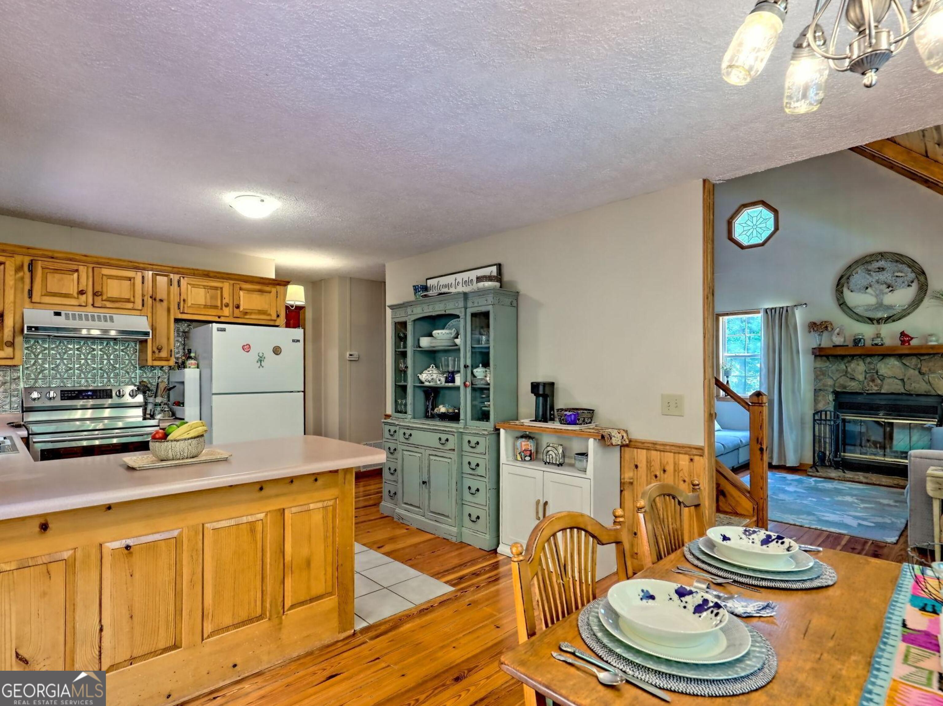 249 Spruce Creek Road Lakemont, GA 30552 - Photo 21 of 55 a large kitchen with stainless steel appliances a stove a sink dishwasher and white cabinets with wooden floor