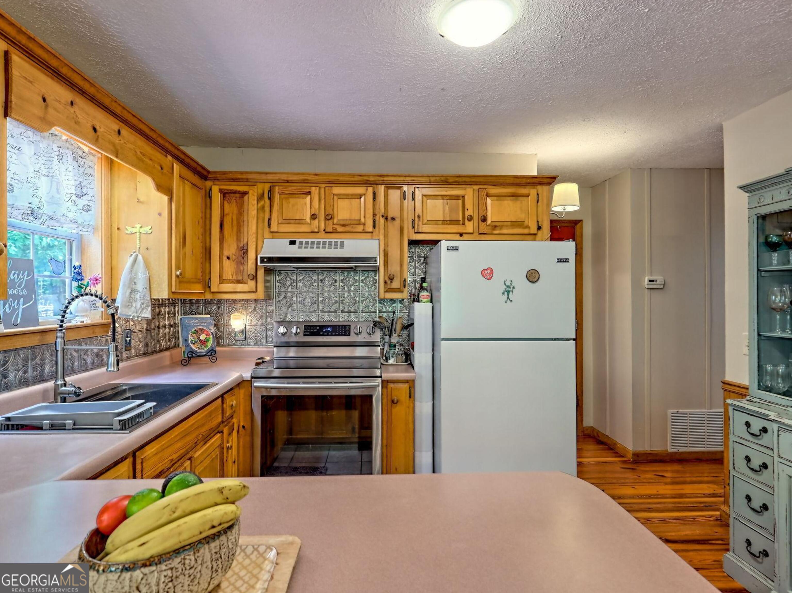 249 Spruce Creek Road Lakemont, GA 30552 - Photo 22 of 55 a kitchen with a refrigerator and a stove
