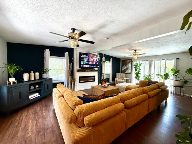 a living room with furniture a ceiling fan and a rug