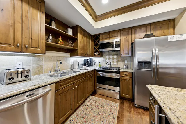 a kitchen with stainless steel appliances granite countertop a sink stove and refrigerator