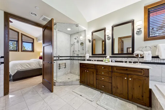 a spacious en suite bathroom with a double vanity granite and a mirror