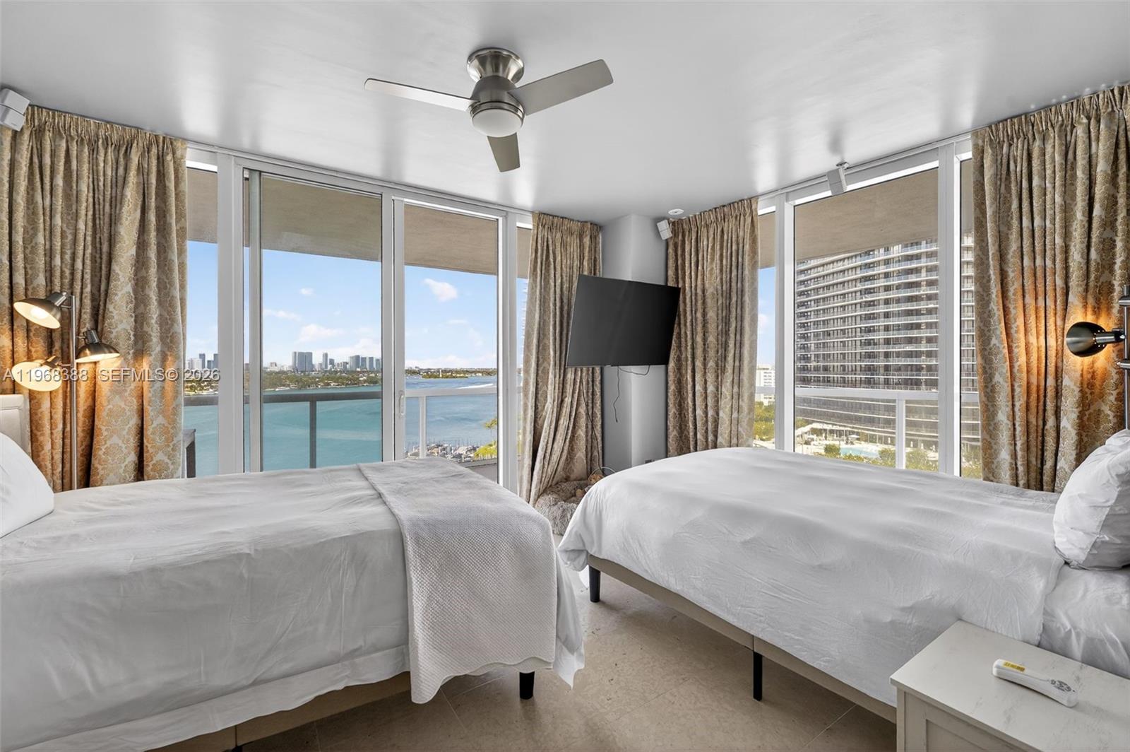 450 Alton Road, Unit 1202 Miami Beach, FL 33139 - Photo 64 of 68 a bedroom with a bed next to a large window with the outer view