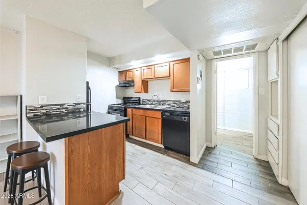 a kitchen with stainless steel appliances granite countertop a stove a sink and a refrigerator