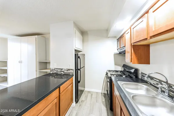 a kitchen with stainless steel appliances granite countertop a sink stove and refrigerator