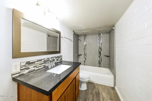 a bathroom with a sink a toilet a mirror and bathtub