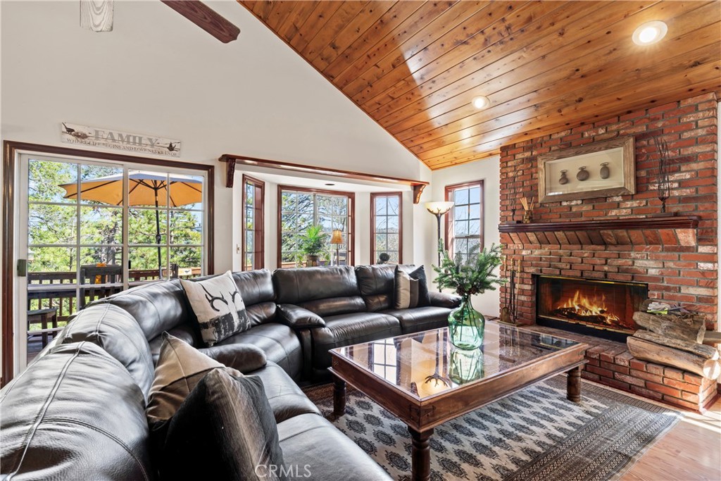221 Grizzly Road Lake Arrowhead, CA 92352 - Photo 6 of 20 a living room with furniture a fireplace and a large window