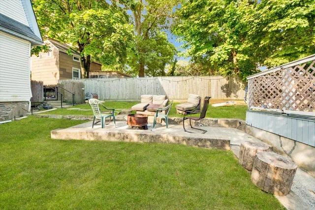 a view of backyard with table and chairs and a large tree