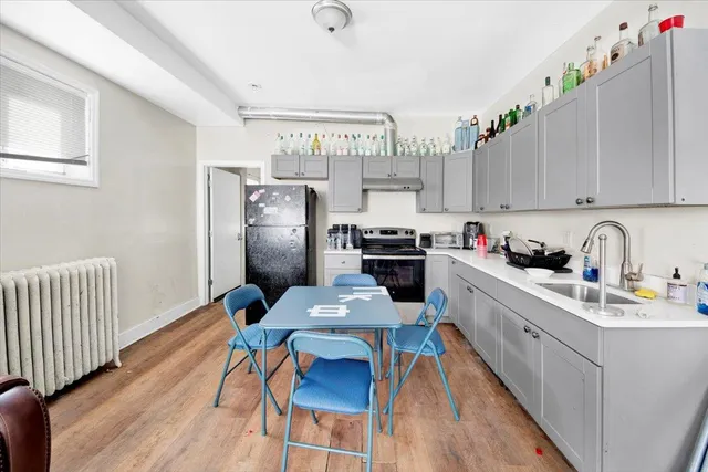 a kitchen with stainless steel appliances granite countertop a refrigerator a sink dishwasher a stove and white countertops with wooden floor