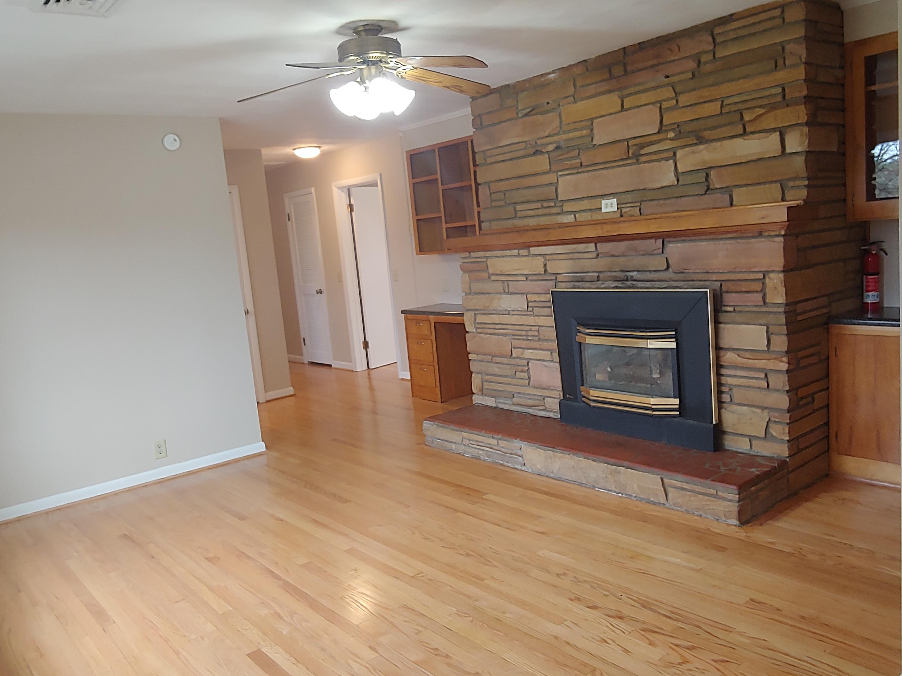 706 Alum Ridge Road Northwest Willis, VA 24380 - Photo 14 of 56 a view of an empty room with wooden floor fireplace and a window