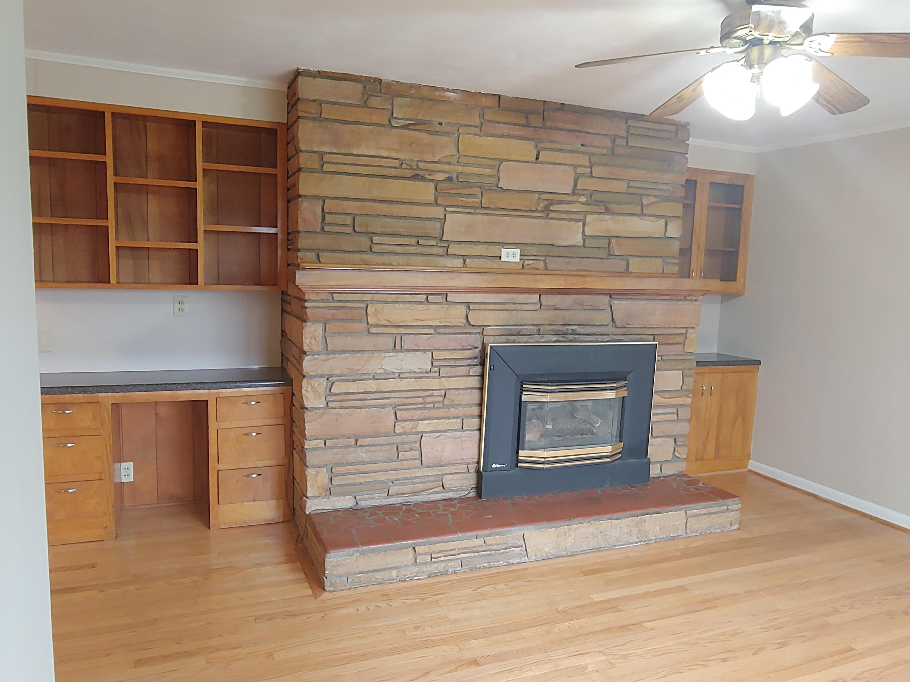 706 Alum Ridge Road Northwest Willis, VA 24380 - Photo 18 of 56 a living room with a fireplace and a ceiling fan