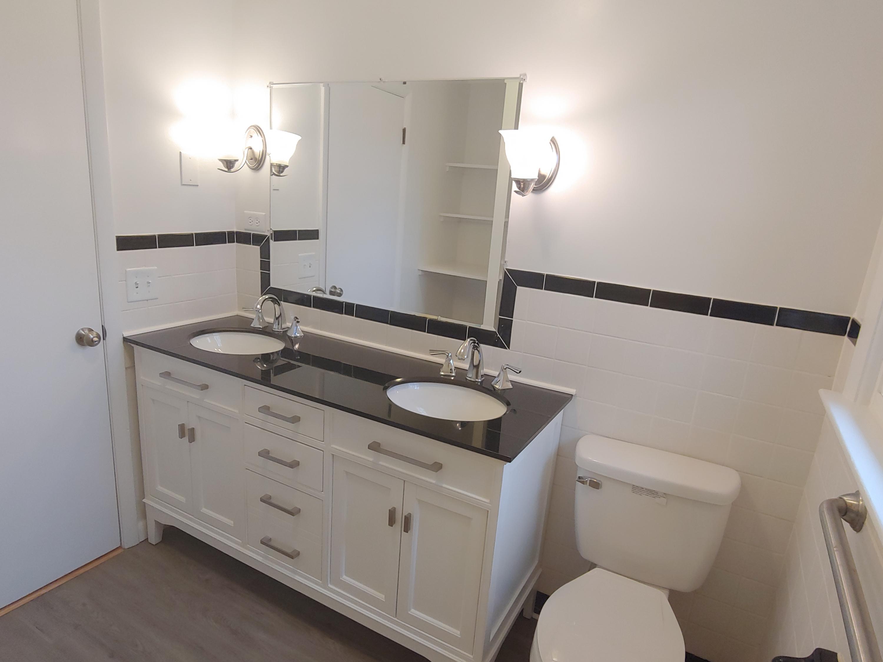 706 Alum Ridge Road Northwest Willis, VA 24380 - Photo 23 of 56 a bathroom with a granite countertop sink a toilet a mirror and shower