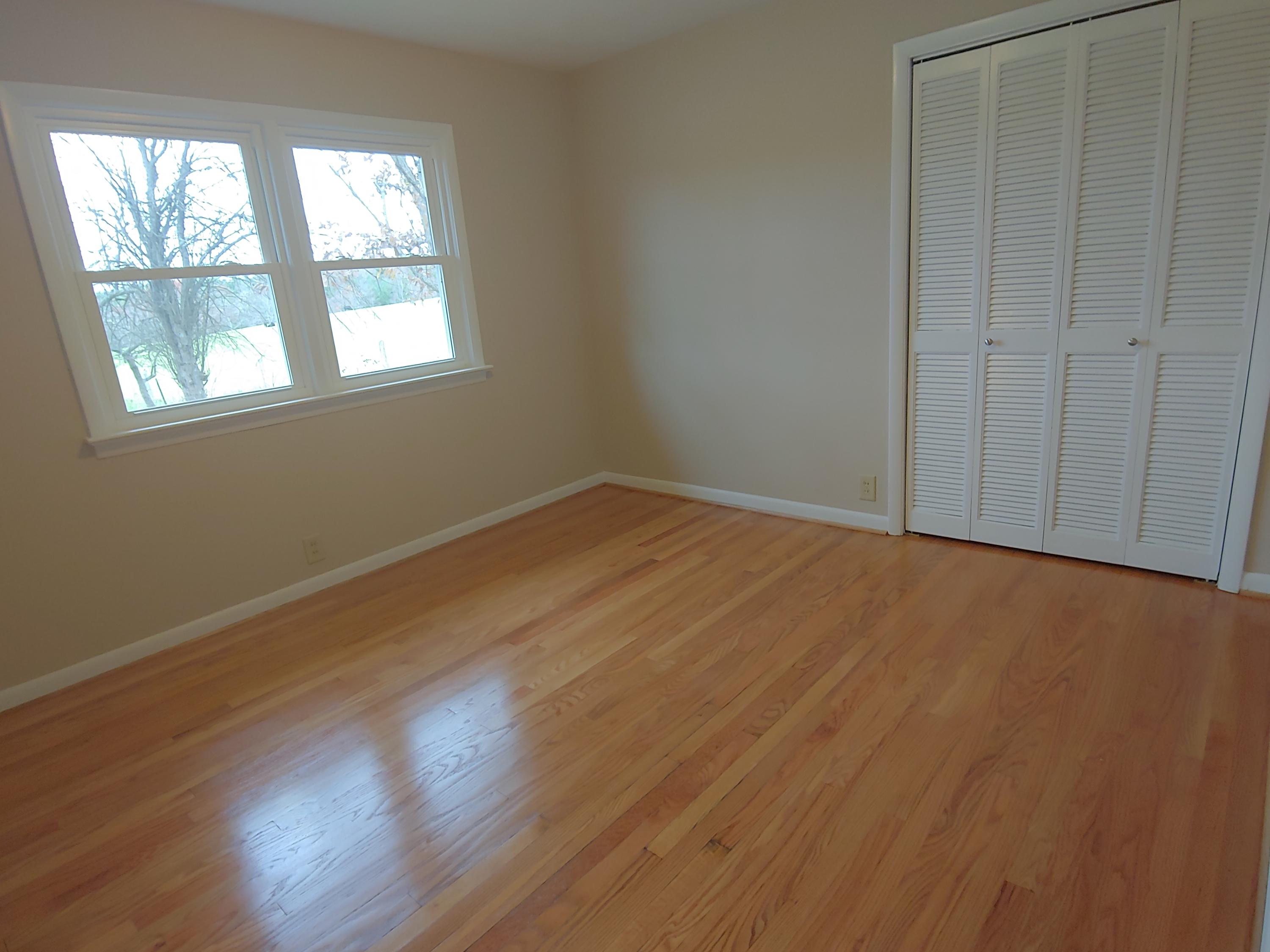 706 Alum Ridge Road Northwest Willis, VA 24380 - Photo 26 of 56 an empty room with wooden floor and windows