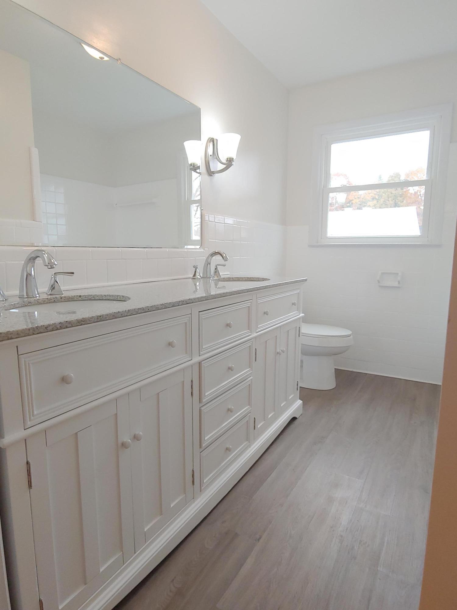 706 Alum Ridge Road Northwest Willis, VA 24380 - Photo 32 of 56 a spacious bathroom with double sink a mirror and a toilet
