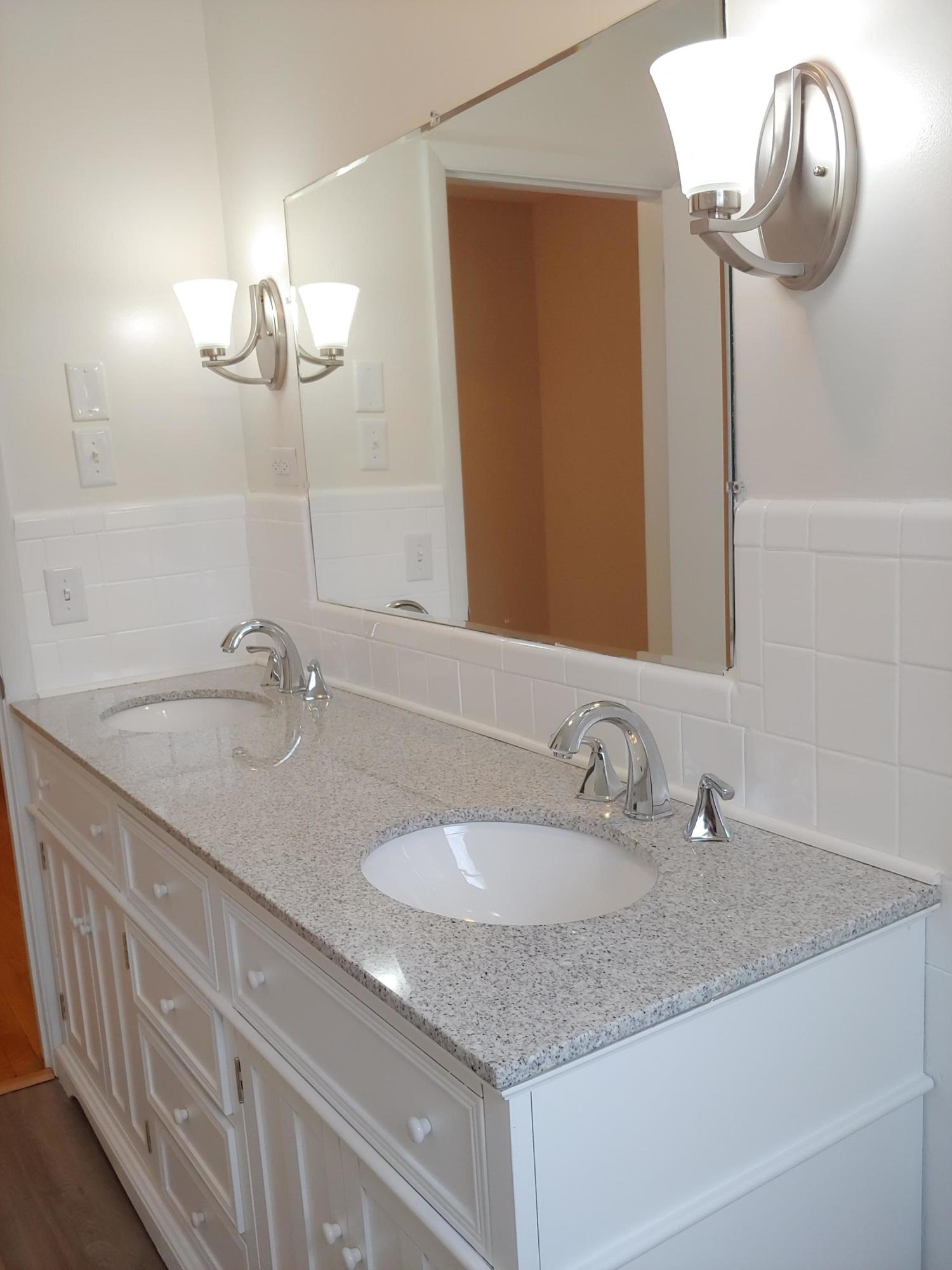 706 Alum Ridge Road Northwest Willis, VA 24380 - Photo 35 of 56 a bathroom with a granite countertop sink and a mirror