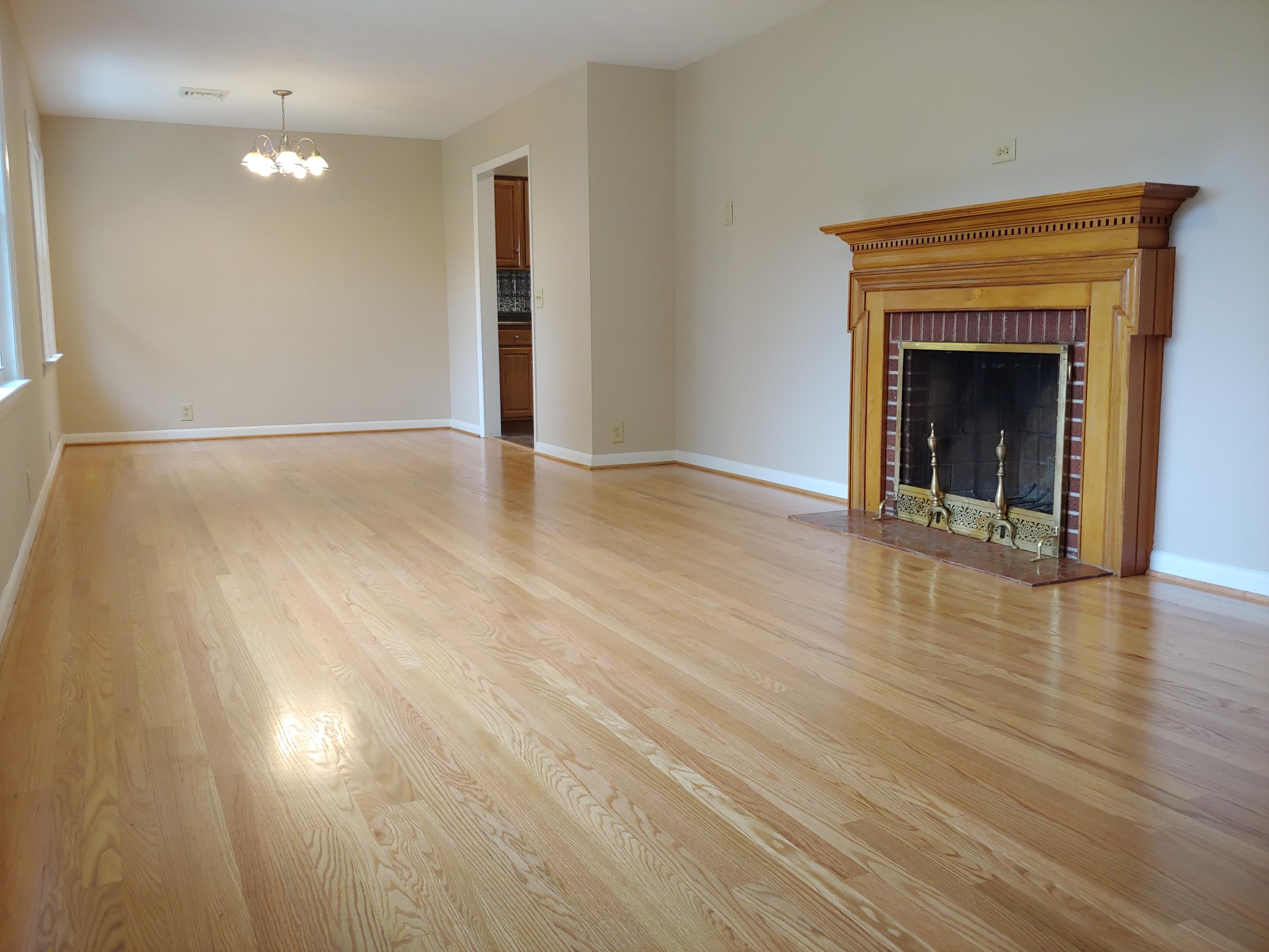 706 Alum Ridge Road Northwest Willis, VA 24380 - Photo 5 of 56 an empty room with wooden floor fireplace and windows