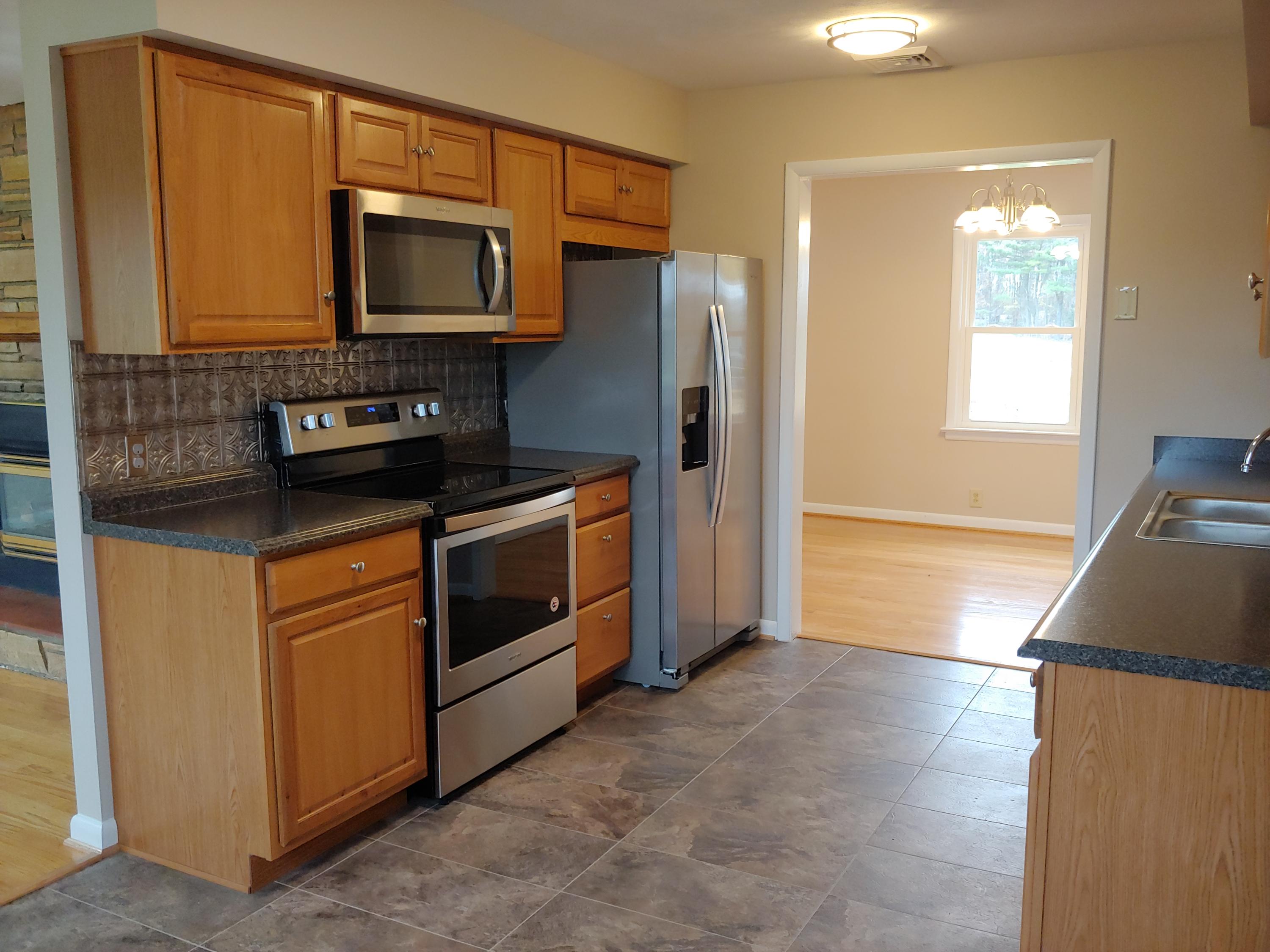 706 Alum Ridge Road Northwest Willis, VA 24380 - Photo 8 of 56 a kitchen with stainless steel appliances granite countertop a stove a microwave and a refrigerator