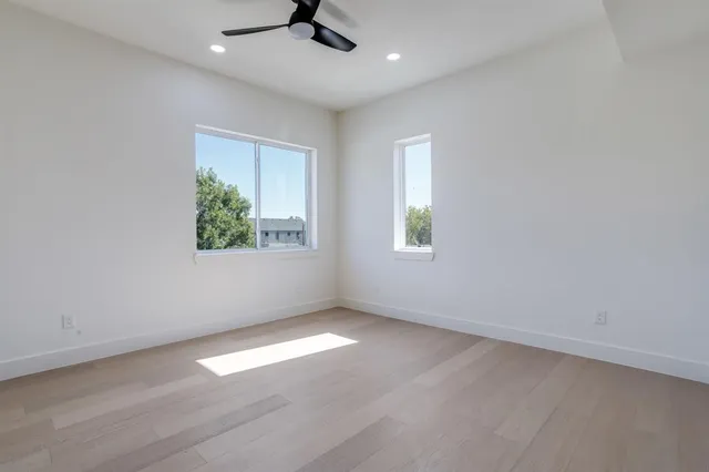 an empty room with a window and a ceiling fan