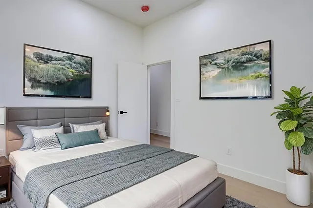 a bedroom with bed and wooden floor