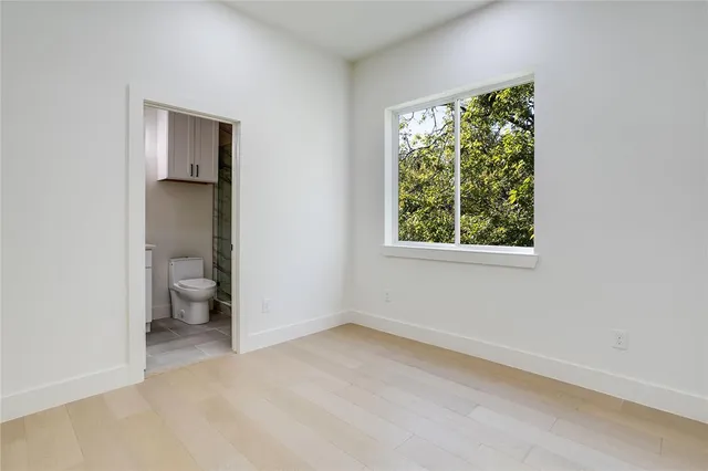 an empty room and a bathroom with toilet