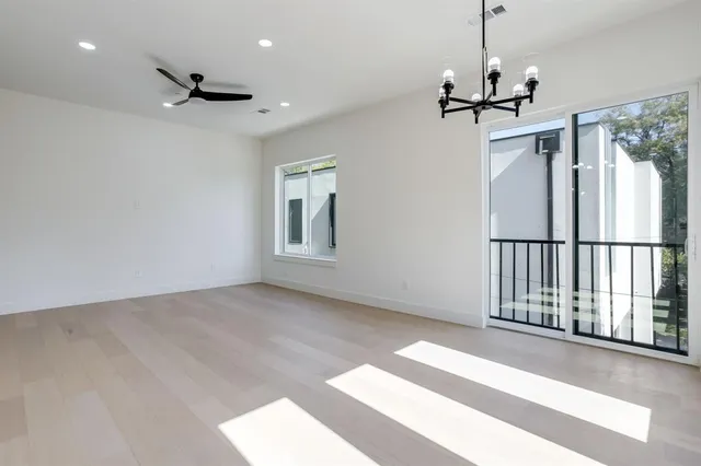a view of empty room with wooden floor and ceiling fan
