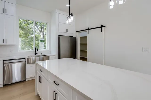 a kitchen with stainless steel appliances a refrigerator sink and cabinets