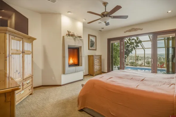a spacious bedroom with a large bed and a chandelier fan