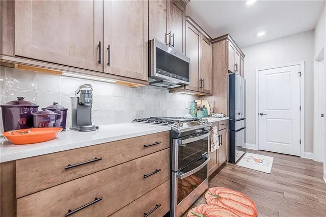 a kitchen with stainless steel appliances granite countertop a stove and white cabinets