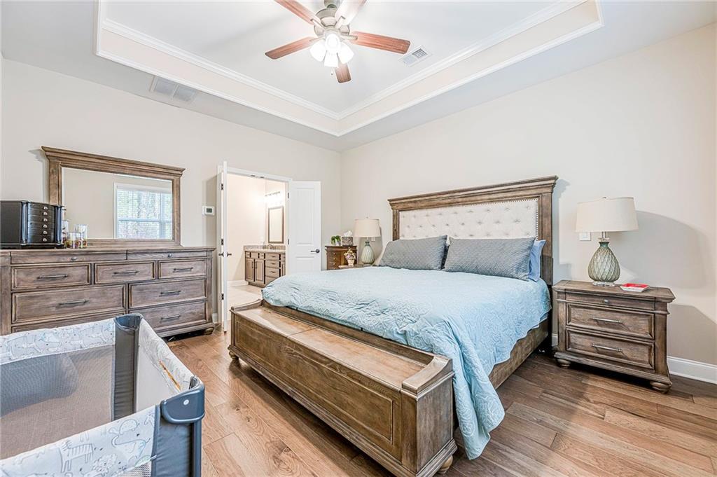 701 Calypso Way Cumming, GA 30040 - Photo 25 of 54 a bedroom with a bed and wooden floor