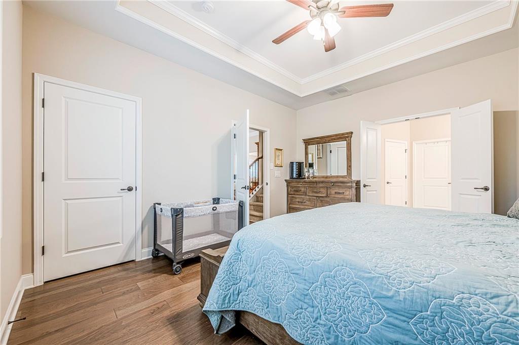 701 Calypso Way Cumming, GA 30040 - Photo 26 of 54 a spacious bedroom with a bed and a chandelier