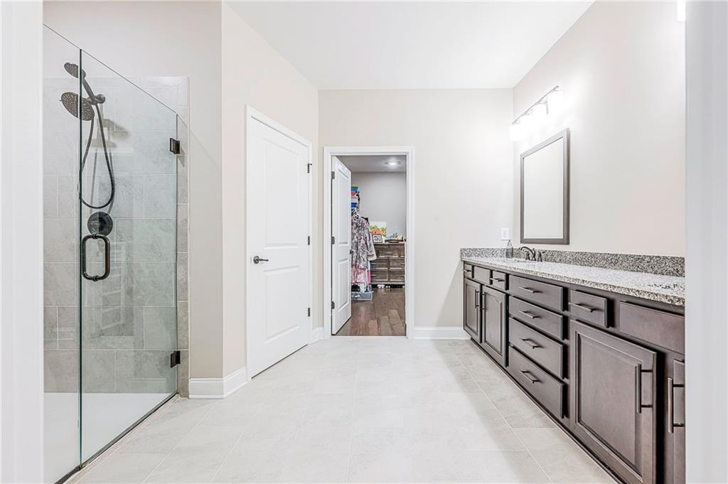701 Calypso Way Cumming, GA 30040 - Photo 28 of 54 a bathroom with a granite countertop sink mirror and shower