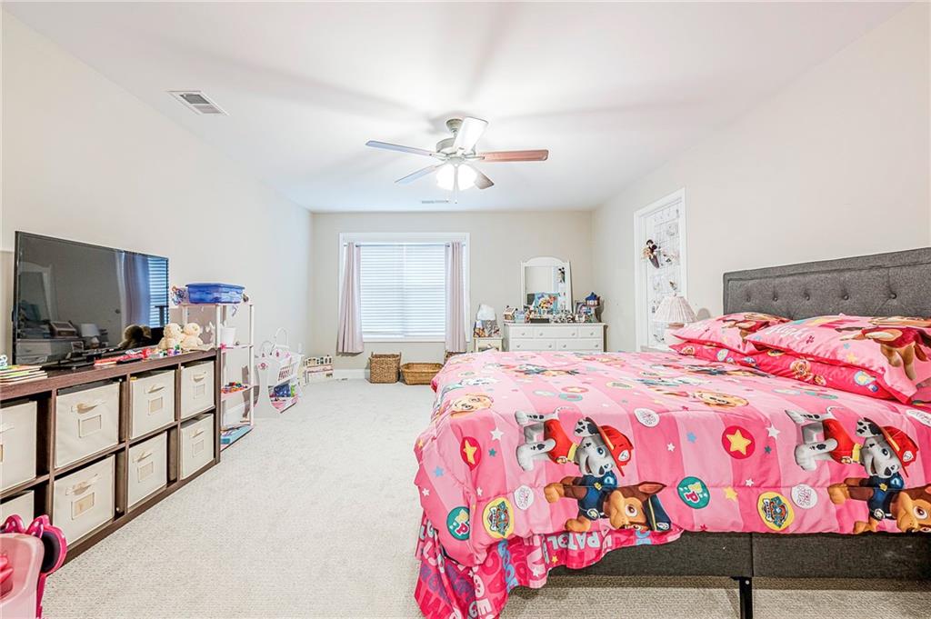 701 Calypso Way Cumming, GA 30040 - Photo 32 of 54 a bedroom with a bed and a chandelier