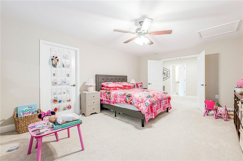 701 Calypso Way Cumming, GA 30040 - Photo 33 of 54 a bedroom with a bed and a chandelier